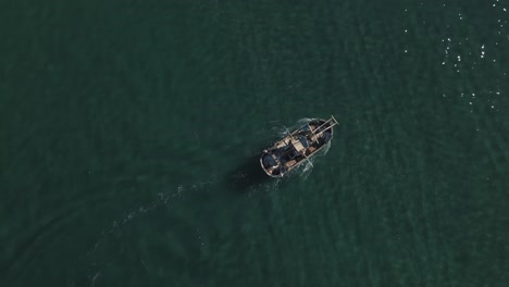 Aerial-view-of-fishing-boat-passing-by-shallow-water