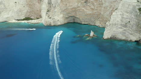 drone-aerial-shot-of-a-boat-tour-near-shipwreck-beach-in-Zakynthos,-Greece