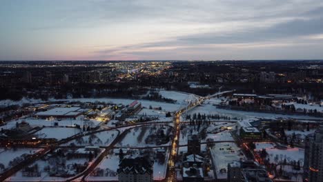 4-4-aerial-panout-evening-winter-city-skyline-over-walter-dale-bridge-the-snow-covered-baseball-stadium-at-birds-eye-view-sunset-with-quiet-streets-highway-at-pandemic-social-distancing-restrictions