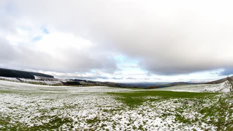 Schneebedecktes-Ländliches-Wintertal-Zeitrafferlandschaft-Wolken-über-Landwirtschaftlicher-Ackerlandlandschaft