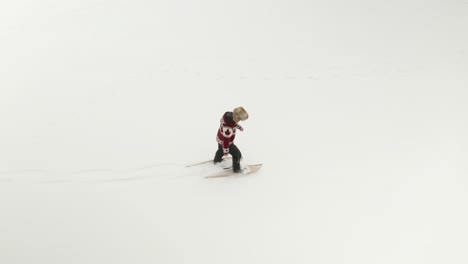 Erwachsener-Mann-Mit-Großer-Pelzmütze,-Geht-Und-Spielt-In-Traditionellen-Schneeschuhen-Auf-Einem-Zugefrorenen-See-Mit-Seinen-Hunden-Im-Norden-Kanadas