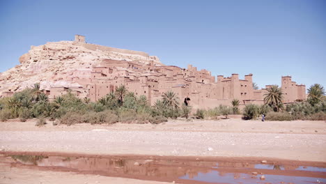 Kasbah-Ait-Ben-Haddou-in-the-Atlas-Mountains-on-a-sunny-day,-slow-motion,-Morocco-North-Africa