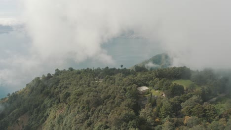 Drone-aerial-view-of-a-forest-in-the-mountains,-high-over-the-clouds-in-Lake-Atitlan-Guatemala