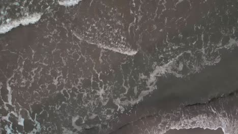 Luftaufnahme-Von-Wellen,-Die-In-Zeitlupe-Am-Sandstrand-Krachen