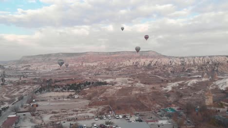 Aerial-4k-drone-footage-of-hot-air-balloons-over-the-desert-landscape-of-Cappadocia,-Turkey