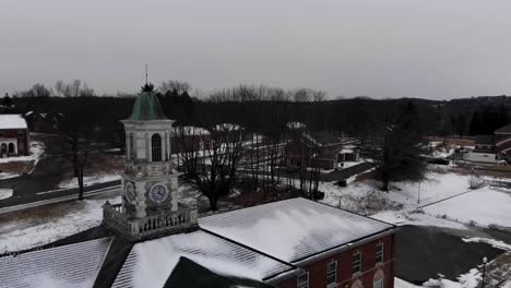 A-winter-drone-shot-flying-by-the-decaying-cupola-and-clock-at-the-abandoned-Fairfield-Hills-Hospital-asylum-in-Newtown,-Connecticut