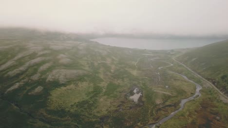 Forward,-crane-drown-drone-shot-over-a-river-in-Nordkapp-with-mist
