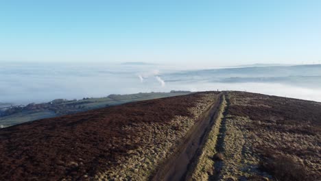 Cloudy-misty-sunrise-valley-aerial-moorland-hiking-hillside-muddy-path-Lancashire-pull-back-left