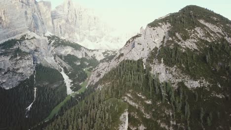 Panning-reveal-drone-shot-in-the-Alps-of-mountains-and-rocky-cliffs