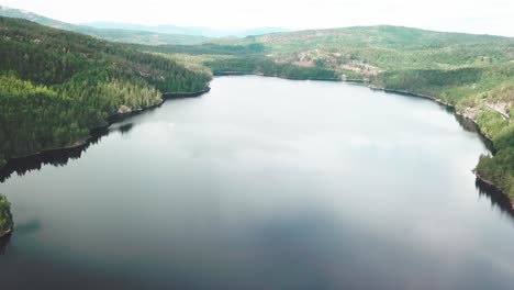 Sideways-movement-of-a-aerial-shot-over-a-lake-surrounded-by-a-forest