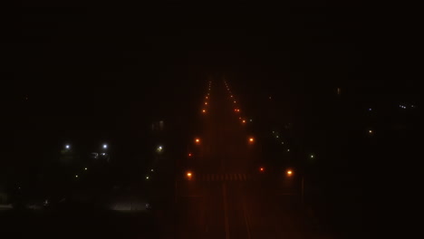 Aerial-Foggy-Road-and-Street-Lights-at-Night-with-an-Empty-Road-in-Romania,-Cluj-Napoca