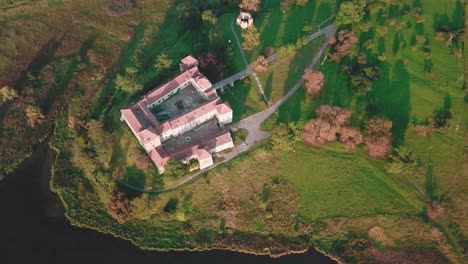 Dolly-high-angle-aerial-shot-of-a-castle-next-to-a-lake