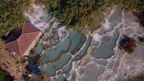 Top-down-of-famous-Terme-di-Saturnia-hot-spring-pools-in-Italy,-aerial