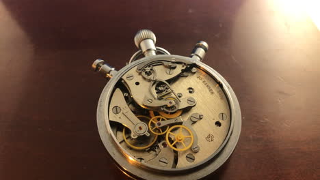 Mechanical-stopwatch-with-exposed-gears-on-mahogany