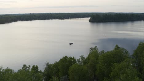 Aerial,-small-personal-fishing-boat-on-a-lake-in-the-United-States-on-an-overcast-day