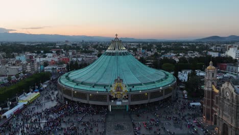 Aerial-view-approaching-the-Basilica-of-Our-Lady-of-Guadalupe,-evening-in-Mexico