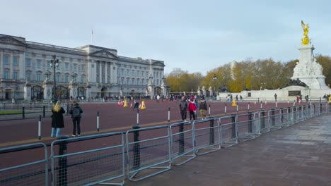 Toma-Panorámica-De-Visitantes-Locales-E-Internacionales-Frente-Al-Palacio-De-Buckingham,-Londres,-Reino-Unido,-Con-Vista-A-Un-Jardín-De-Césped-En-Frente-Durante-El-Día