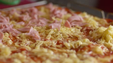 Adding-ham-onto-a-pizza-before-baking-it