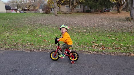 Close-up-shot-of-kid-in-yellow-jacket-riding-the-bike-in-winter