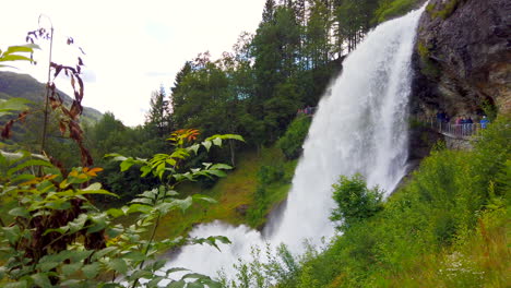 Spectacular-Steinsdalsfossen-thundering-Norwegian-waterfall-that-one-can-walk-behind-near-village-of-Steine,-Norway,-static-wide-framed-from-side-4k-prorezHQ