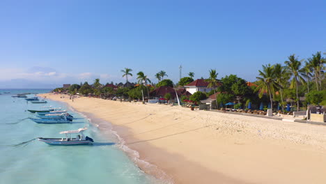 Vista-Aérea-De-Bali-Indonesia-Sunset-Beach-En-Nusa-Lembogan,-Clima-Tropical-Con-Palmeras-Océano-Azul,-Arena-Blanca-Y-Veleros