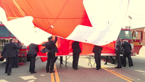 Polizisten-Falten-Die-Massive-Kanadische-Flagge,-Die-Von-Einem-Feuerwehrkran-Nach-Der-Beerdigung-Für-Den-Polizisten-Andrew-Hong-Aus-Toronto-In-Toronto,-Kanada,-Gehisst-Wurde