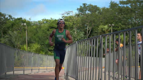 Jugendlicher-Lateinamerikanischer-Athlet,-Der-An-Einem-Sonnigen-Tag-Die-Letzte-Etappe-Eines-Triathlon-Wettbewerbs-Zwischen-Schienen-Mit-Sonnenbrille-Durchläuft