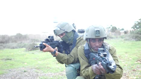 Revelando-Dos-Soldados-De-Infantería-Del-Ejército-Israelí-De-Las-FDI-Arrodillados-Apuntando-Con-Ametralladoras-Al-Campo-De-Batalla