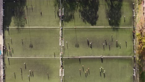 Time-lapse-top-down:-Many-Soccer-Player-running-on-football-field-during-training-session-in-sunlight---Many-Soccer-fields-at-university-of-Buenos-Aires---Aerial-top-view