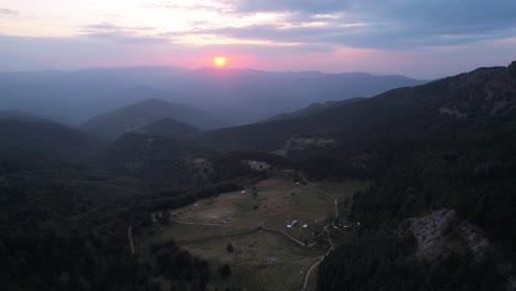 Ascending-drone-shot-in-Bulgarian-mountains-near-Plovdiv,-Krichim-with-the-sun-setting-in-the-distance