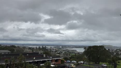 Lapso-De-Tiempo-De-Un-Día-Nublado-Gris-Sobre-Auckland-Nueva-Zelanda-Con-Autos-Moviéndose-En-Primer-Plano