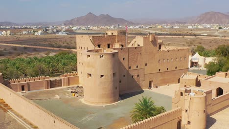 Whimsical-Jabreene-Castle-in-the-Sultanate-of-Oman,-Aerial-dolly-out