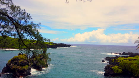 Pan-of-beautiful-Keawaiki-Bay-with-blue-Pacific-Ocean,-black-lava-rocks-on-Road-to-Hana,-Maui,-Hawaii-4k-ProRezHQ