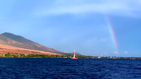 Spectacular-rainbow-over-West-Maui,-Pacific-Ocean-at-beautiful-Lahaina-Ka'anapali-beach-at-sunset-in-Hawaii-from-sail-boat-at-sea,-4k-ProRezHQ