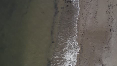 Ruhige-Wellen,-Die-Von-Oben-An-Einem-Sandstrand-Brechen