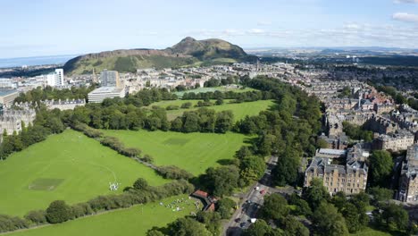 Aerial-shot-over-Edinburgh-University-buildings-and-the-Meadows,-towards-Arthur's-Seat,-on-a-sunny-day-|-Edinburgh,-Scotland-|-4K-at-30-fps