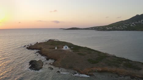 Drone-aerial-view-of-a-white-church-during-sunrise-in-Greece