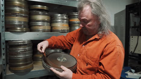 A-man-in-a-film-tape-warehouse-inspects-an-old-film-tape