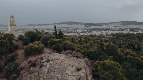 Blick-Auf-Einen-Mann,-Der-Am-Fuße-Des-Hügels-Der-Akropolis-In-Athen,-Griechenland,-Steht---Luftumlaufbahn