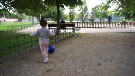 Little-girl-kicking-ball-in-park,-slow-motion