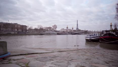 Empty-scenery-of-Paris-river-La-Seine-with-a-view-of-the-Eiffel-Tower-during-lockdown-during-the-Covid-19-pandemic,-tourism-in-France-on-a-cloudy-day