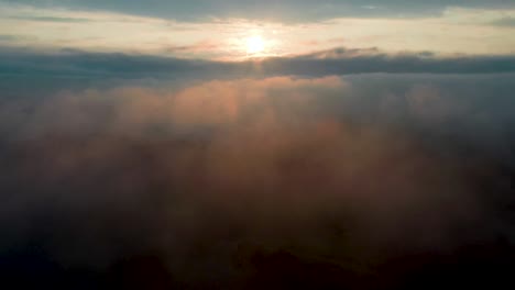 Aerial-Tilt-Up-Reveal-of-beautiful-Sun-Rays-from-Sunrise-in-the-Clouds