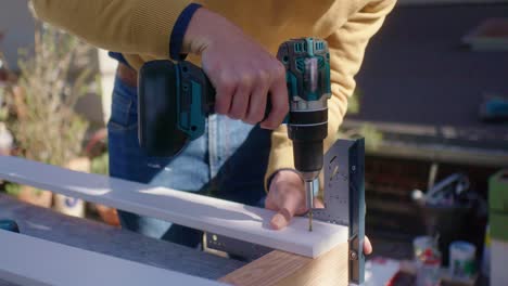 The-craftsman-drills-a-screw-into-the-wood