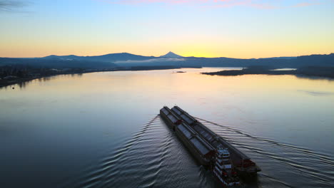 Aerial-drone-view-of-a-large-ship-laying-in-the-middle-of-a-big-lake-during-sunrise