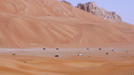 Off-Roading-Club-Enthusiasts-During-Dune-Bashing-In-Golden-Sand-Desert-Near-Fossil-Rock-In-Sharjah,-United-Arab-Emirates---Wide-Shot