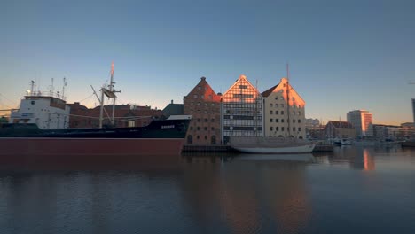 long-ship-at-Motlawa-river-Gdansk-Poland,-building-around-golden-hour-shot
