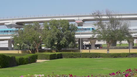 Tren-De-Metro-De-Dubai-Con-Tráfico-En-La-Autopista-Desde-El-Parque-Vacío-De-Al-Rashidiya-En-Dubai,-Emiratos-árabes-Unidos