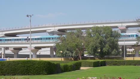 Metro-De-Dubai-Estacionado-En-El-Viaducto-Elevado-De-La-Estación-De-Metro-Al-Rashidiya-Desde-El-Parque-Rashidiya-En-Dubai,-Emiratos-árabes-Unidos