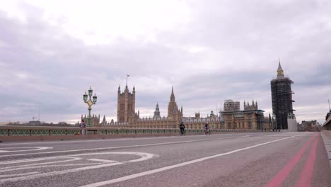 Quiet-day-on-Westminster-Bridge-in-London,-view-of-Westminster-Parliament-and-Big-Ben-under-renovation-work-and-construction,-empty-scenery-in-slow-motion-during-Covid-19-Coronavirus-pandemic