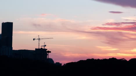 City-Cranes-Silhouette-by-Bright-Sunset-Timelapse
